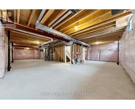 A spacious unfinished room with wooden beams on the ceiling.