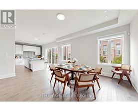 A dining room with a table set for six with a view of a brick building outside the window.