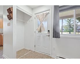A white door with a window and curtains is in a room.