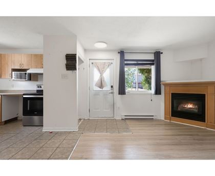 A modern kitchen with a stainless steel oven and a fireplace in the living room.