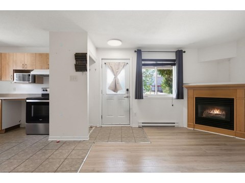 A modern kitchen with a stainless steel oven and a fireplace in the living room.