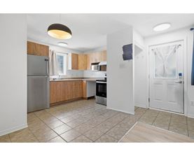 A kitchen with a refrigerator, microwave, and oven.