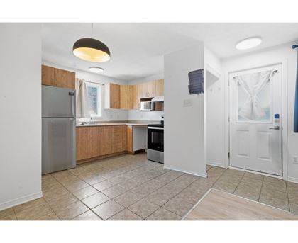 A kitchen with a refrigerator, microwave, and oven.