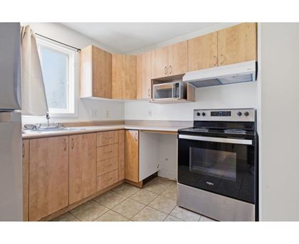 A kitchen with wooden cabinets and a black oven.
