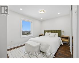 A bedroom with a large bed and a window overlooking the trees.