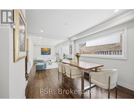 A dining room with a wooden table and chairs.