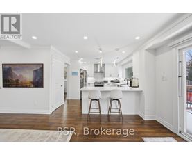 A kitchen with white cabinets and a painting on the wall.