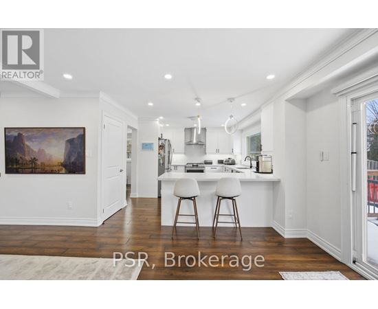 A kitchen with white cabinets and a painting on the wall.