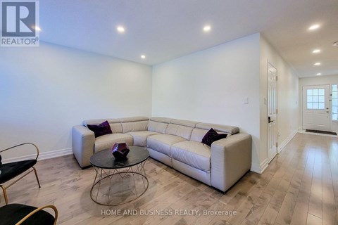 A living room with a white couch and a glass coffee table.