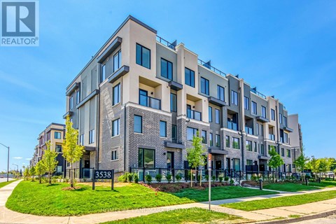 A modern apartment building with a clear blue sky in the background.