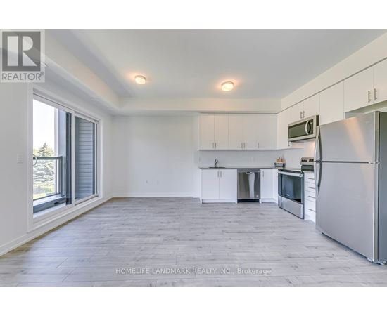 A spacious kitchen with white cabinets and stainless steel appliances.