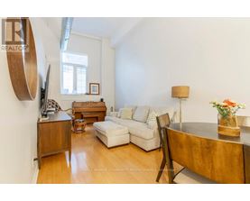 A living room with a white couch, a wooden coffee table, and a lamp.