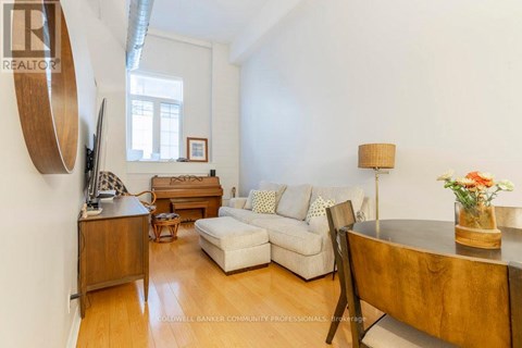 A living room with a white couch, a wooden coffee table, and a lamp.