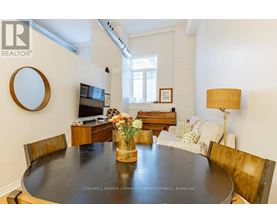 A dining room with a wooden table and chairs.