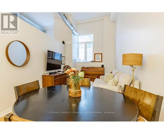 A dining room with a wooden table and chairs.