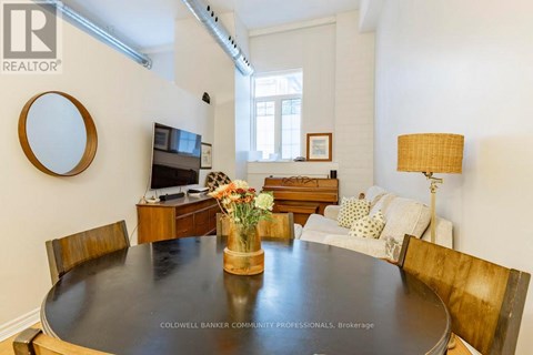 A dining room with a wooden table and chairs.