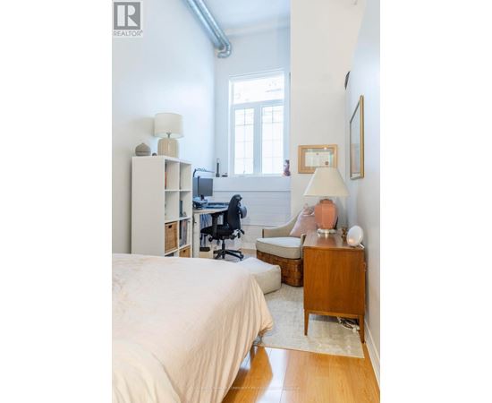 A bedroom with a bed, desk, and chair.