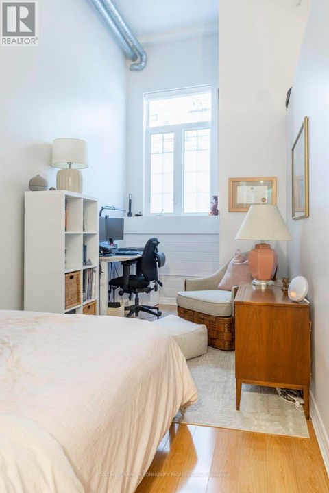 A bedroom with a bed, desk, and chair.