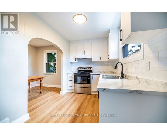 A modern kitchen with white cabinets and a marble countertop.