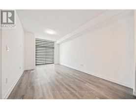 A spacious room with wooden flooring and white walls.