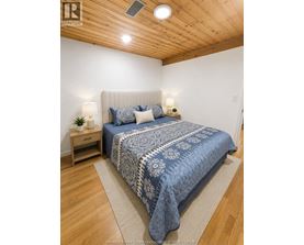 A bedroom with a bed, nightstands, and a rug.