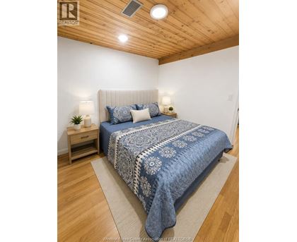 A bedroom with a bed, nightstands, and a rug.