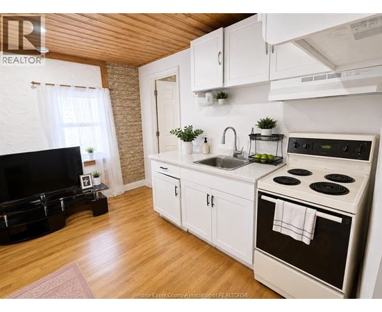 A kitchen with white cabinets and a black stove top.