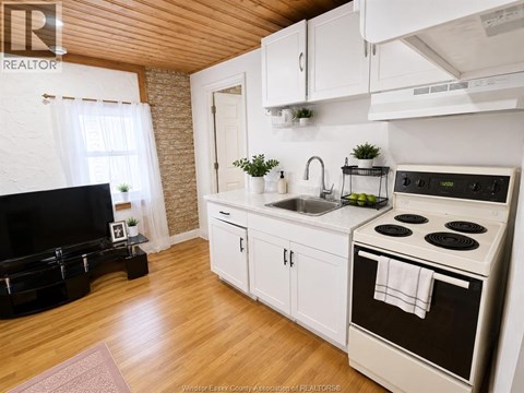 A kitchen with white cabinets and a black stove top.