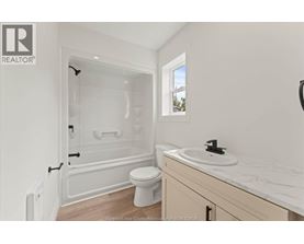 A white bathroom with a toilet, sink, and bathtub.