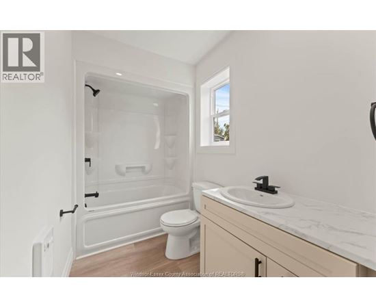 A white bathroom with a toilet, sink, and bathtub.