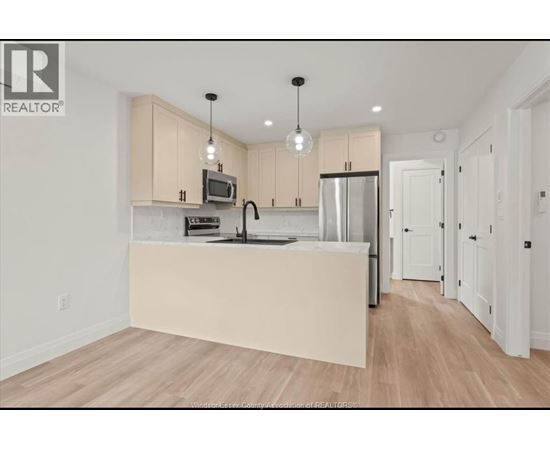 A kitchen with wooden floors and white walls.