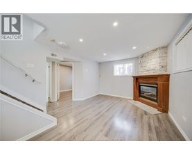 A spacious living room with a fireplace and wooden flooring.