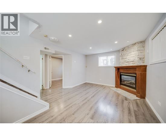 A spacious living room with a fireplace and wooden flooring.