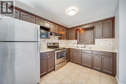 A kitchen with brown cabinets and a white refrigerator.