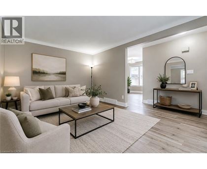 A living room with a white sofa, a coffee table, and a painting on the wall.