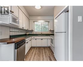 A kitchen with white cabinets and a wooden floor.