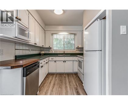 A kitchen with white cabinets and a wooden floor.