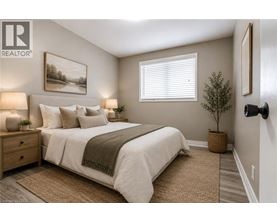 A well-lit bedroom with a large bed and a painting on the wall.
