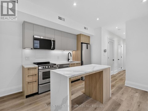 A modern kitchen with a white island in the middle.