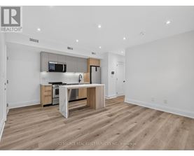 A modern kitchen with wooden floors and white walls.