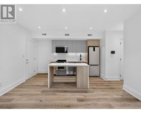 A modern kitchen with a wooden island and stainless steel appliances.