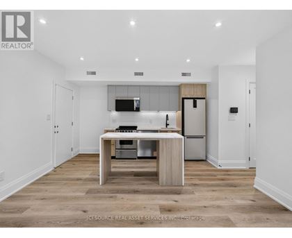 A modern kitchen with a wooden island and stainless steel appliances.