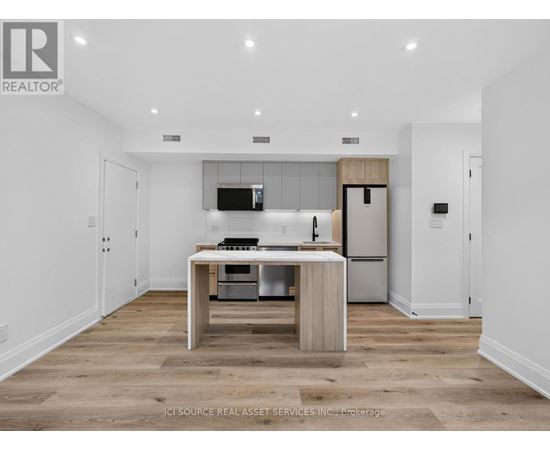 A modern kitchen with a wooden island and stainless steel appliances.