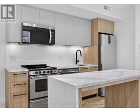 A modern kitchen with a stainless steel refrigerator, microwave, and oven.