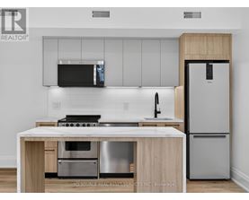 A modern kitchen with a stainless steel refrigerator and a wooden island.
