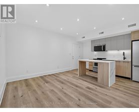 A modern kitchen with wooden flooring and white walls.