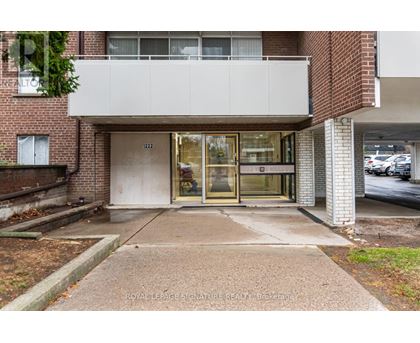 A building entrance with a glass door and a sign that says "ROYAL LEPAGE SIGNATURE READY Brokerage".