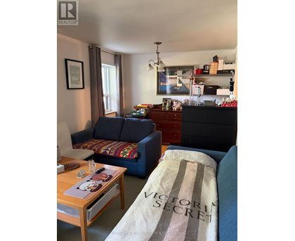 A living room with a sofa, coffee table, and a dresser.