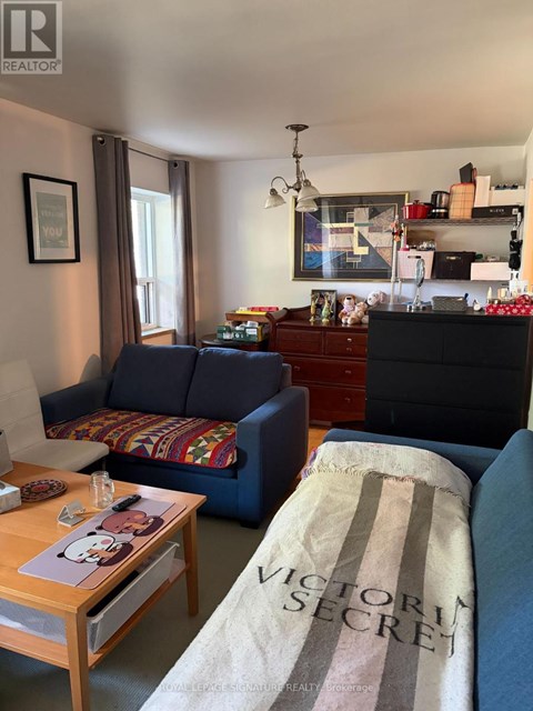 A living room with a sofa, coffee table, and a dresser.