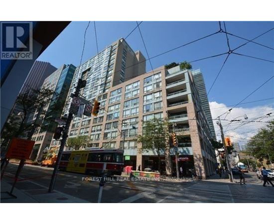 A street view of a city with a building in the background and a sign that says Forest Hill Real Estate.